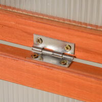 Wetterfestes oranges Frühbeet aus Holz und Polycarbonat, schützt Pflanzen vor Witterungseinflüssen und fördert das Wachstum.