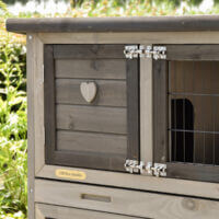 Nahaufnahme des Herzmotivs an der Tür des Hasenstalls Adrian mit Metallriegel und Qualitätsplakette.