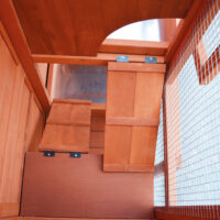 Holzhasenstall in Rot-Braun mit wetterfestem Dach und Türen für einfachen Zugang.