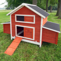 Kompakter roter Hühnerstall mit geschütztem Nistbereich.