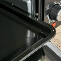 Ein schwarz-silberner Minibackofen und Kompaktofen mit 21 Litern Fassungsvermögen und 3 Kochmodi.