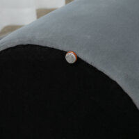 Eine runde graue Ottomane mit Stauraum und 2-in-1 Funktion.