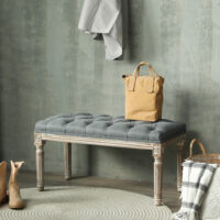 Graue Polsterbank im Vintage-Stil mit eleganter Knopfverzierung. Ein zeitloses Möbelstück für klassische Einrichtungen.