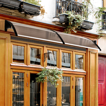 Braunes Pultvordach aus Polycarbonat mit UV-Schutz, 75x195x23cm, bietet Schutz vor Regen und Sonne über Türen und Fenstern.