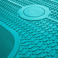 Nahaufnahme der rutschfesten Oberfläche eines weißen und grünen Reebok Stepbretts. Die strukturierte Oberfläche sorgt für zusätzlichen Halt und Sicherheit bei intensiven Workouts.