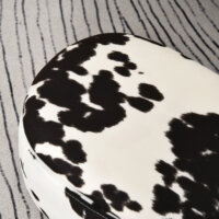 Ein niedlicher Tierhocker im Schweinchen-Design mit integriertem Stauraum in Schwarz-Weiss.