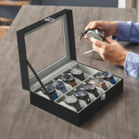 Elegante Uhrenbox aus schwarzem PU-Leder mit Glasdeckel und dunkelgrauen Nähten. Bietet Platz für 10 Uhren, schützt vor Staub und Kratzern und präsentiert die Sammlung stilvoll. Maße: 21 x 25 x 8,5 cm, Gewicht: 0,9 kg.