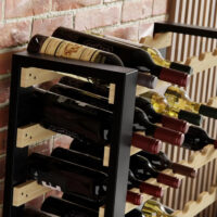 Nahaufnahme des Weinregals "Loft" aus Kiefernholz. Die Aufnahme zeigt die präzise Verarbeitung, die Maserung des Holzes und die elegante Form der Flaschenhalter.